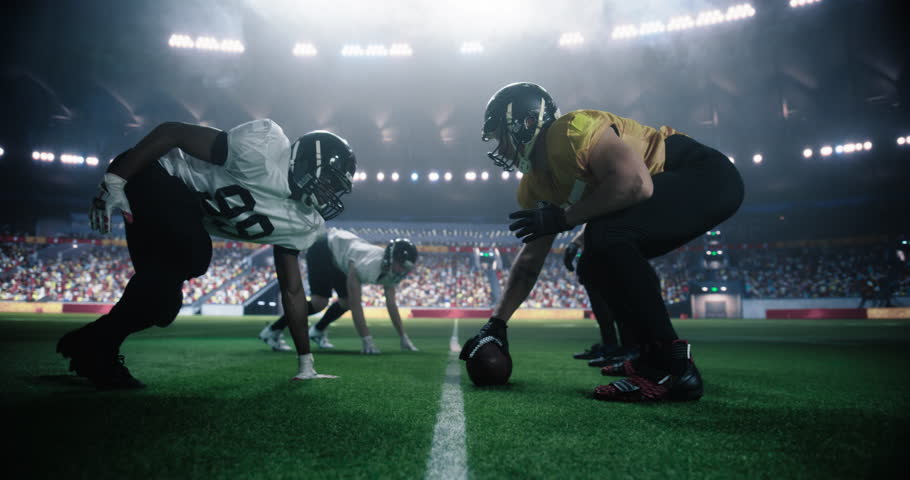 Strong Masculine Defensive Players Holding Off Competitors After Making a Pass. Intense Action From an American Football Match During a Night Championship Game with Athleticism Sportsmen