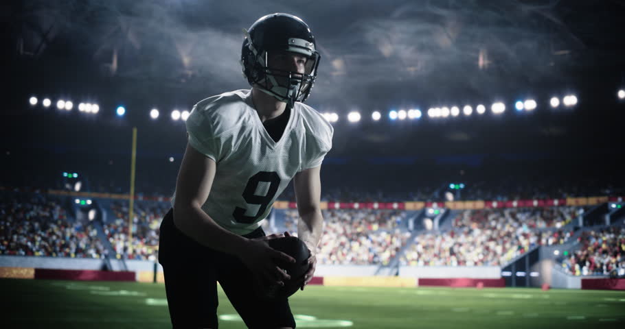 American Football Match in a Crowded Stadium: Player in White Uniform Throwing the Ball to His Teammate to Score a Run at the End Zone. Footballers Battle for Championship Win