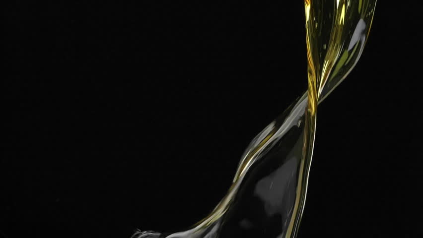 Slow motion shot of motor oil falling down on black background. 

