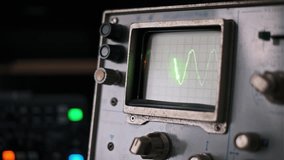 A hand adjusts a knob on a vintage oscilloscope, modifying the green waveforms displayed on the screen. This captivating footage blends analog technology with hands-on control. - Powered by Shutterstock - Get 15% off with code: PIKWIZARD15