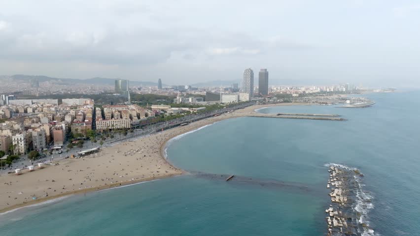 Aerial drone panorama of Villa Olimpica del Poblenou, in the city of Barcelona. Twin skyscrapers of Hotel Arts and Torre Mapfre next to Port Olimpic.