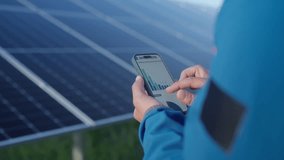 Close-up of a Solar Technician Using a Smartphone App in the Photovoltaic Solar Panels Field. Concept of Clean Renewable Green Energy, Energy Efficiency, Occupation, Future, Ecology, Savings, Graph - Powered by Shutterstock - Get 15% off with code: PIKWIZARD15