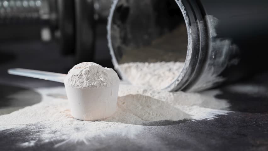 Amino acid food supplement, creatine powder in a measuring scoop and plastic jar