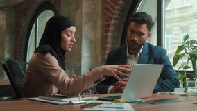 Diverse business partners colleagues Indian Arabian man Muslim islamic woman hijab talk discuss project on laptop at office corporate teamwork multiracial businessman businesswoman consult discussion - Powered by Shutterstock - Get 15% off with code: PIKWIZARD15
