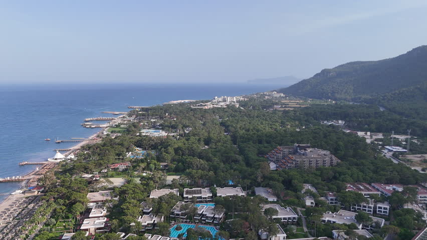 Flying over a Turkish hotel in Kemer, near the mountains 4k footage