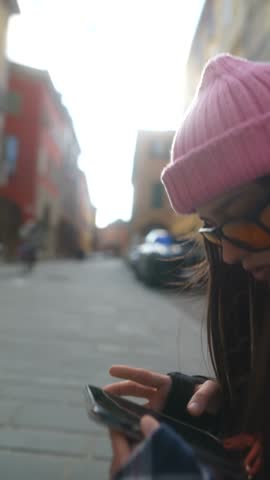 A cheerful young tourist uses a digital map to get to know a new Italian city.