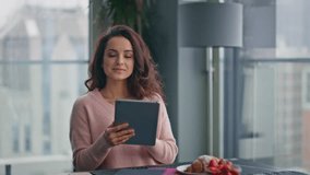 Husband bringing tea wife at cozy glass kitchen closeup. Cute brunette woman holding digital tablet showing to smiling man. Married pair enjoying coffee break relaxing together at panoramic apartment - Powered by Shutterstock - Get 15% off with code: PIKWIZARD15