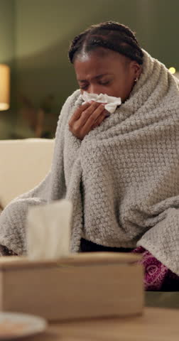 Sick, tissue and woman on sofa with blanket for allergies, infection and flu virus in living room. Healthcare, medical and person on couch sneeze for hayfever, influenza and sinus symptoms in home