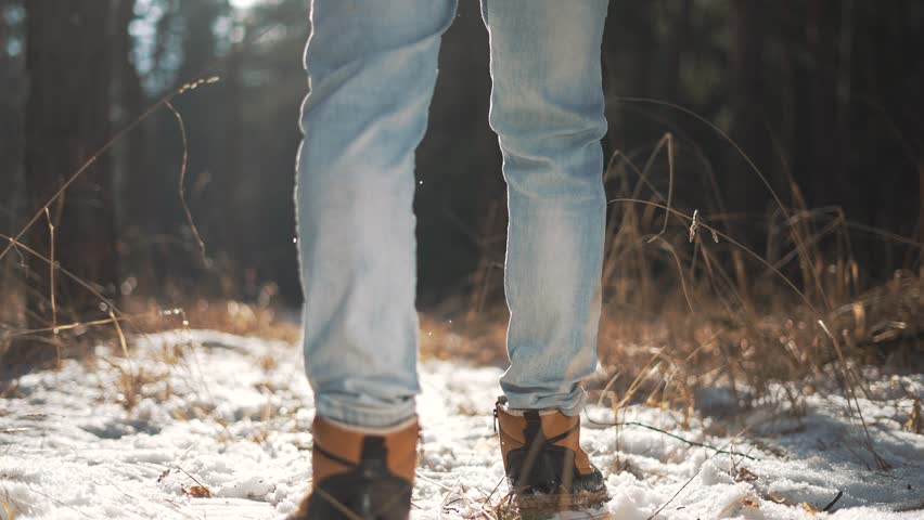 Tourist feet in snow, embodying freedom with every winter forest walk. journey of solitude and freedom in snow covered woods. Walk in winter forest, step toward freedom in nature silence. leg close up
