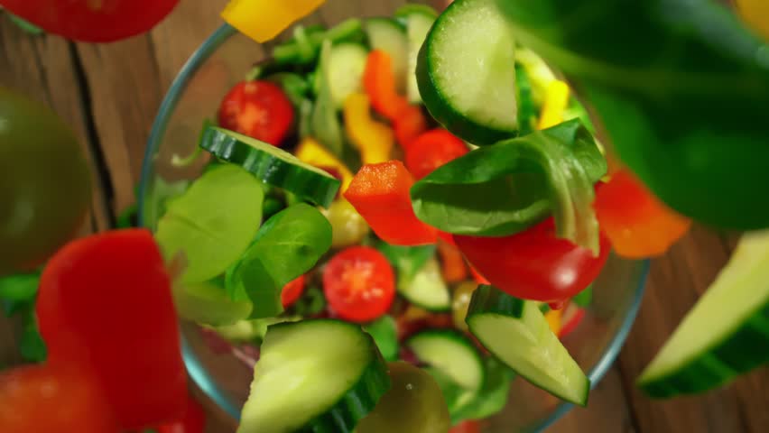 Super Slow Motion Shot of Fresh Salad Ingredients Following by Camera Falling into Bowl at 1000fps.