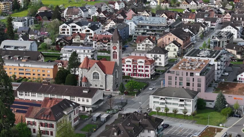 Municipality of Walenstadt in Switzerland. A small town living its life in the alpine mountains. Drone view of church and street with passing cars