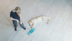 A teenage girl washes the floor from traces of her pet's paws. The dog lies nearby - Powered by Shutterstock - Get 15% off with code: PIKWIZARD15