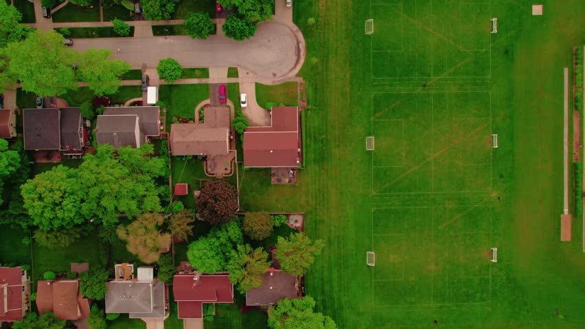 Elevated view of houses in Chicago suburbs adjacent to multiple soccer fields. High income households.
