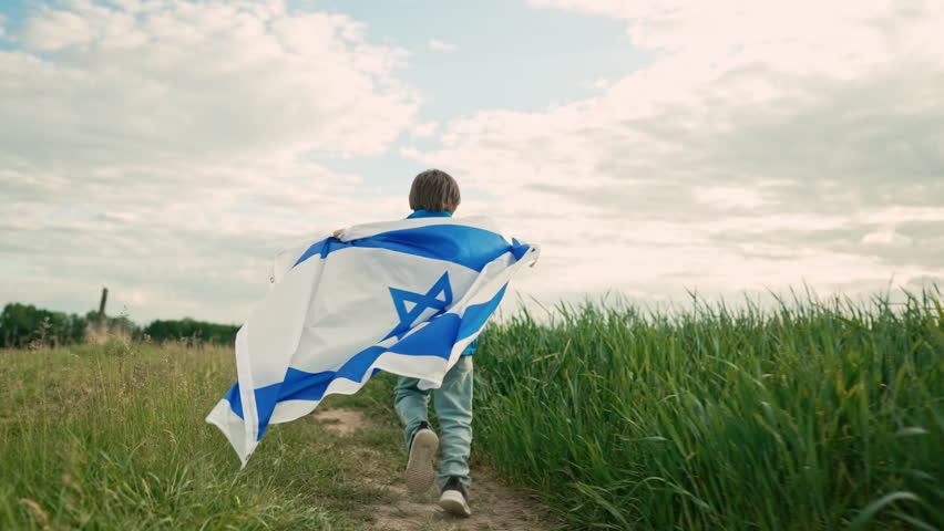Happy israeli jewish little boy runs with Israel national flag. Independence Day. Patriotism.