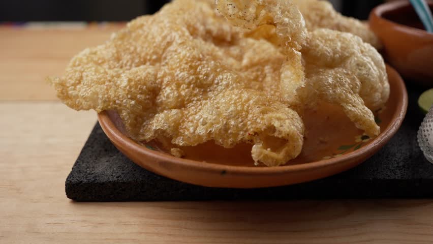 pork rinds in a clay plate with red sauce