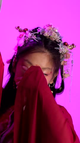 A woman in a red dress with a flowery headpiece poses for a photo. The image has a bright and cheerful mood, with the woman