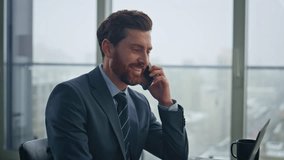 Closeup happy businessman calling mobile phone sitting cityscape office. Positive confident manager talking smartphone looking documents at workplace. Elegant boss consulting client at telephone  - Powered by Shutterstock - Get 15% off with code: PIKWIZARD15