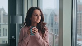 Peaceful woman sipping tea looking panoramic window in morning closeup. Dreamy girl thinking life enjoying cappuccino at home. Smiling lady drinking coffee contemplating at modern apartment interior - Powered by Shutterstock - Get 15% off with code: PIKWIZARD15