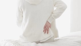 A woman caring about her painful lower back - Powered by Shutterstock - Get 15% off with code: PIKWIZARD15