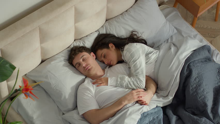 Couple love man woman sleep on bed bedroom home cosy wake up together happiness weekend rest daydream napping soft mattress warm apartment tenderness sweetheart intimacy cuddle harmony marriage warmth