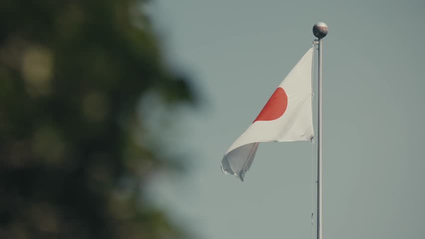 Japanese Flag On Flagpole Waving With The Wind. - close up shot
