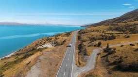 Aerial follow view of a van driving next to lake Pukaki in summer time in New Zealand. - Powered by Shutterstock - Get 15% off with code: PIKWIZARD15