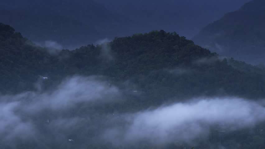 Mountains in clouds at evening in summer. mountain peak with green trees in fog. Beautiful landscape with high mountains, forest, sky. munnar kerala mountain valley and low clouds flying