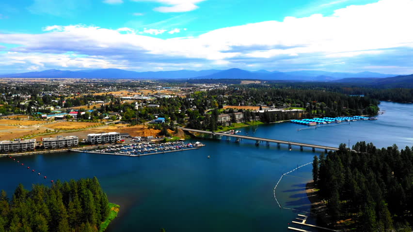 Aerial Panning Scenic View Of Harbor By Bridge In Rippled River, Drone Flying Over Green Trees On Sunny Day. - Coeur d