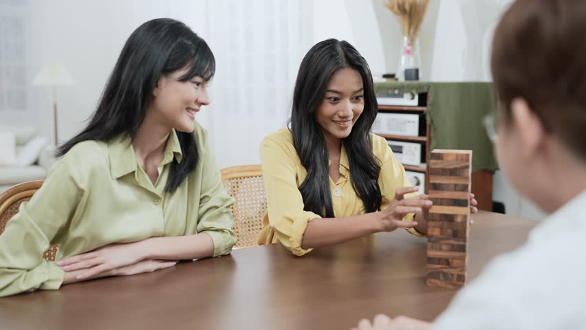 Holiday concept of 4k Resolution. Group of Asian female friends playing games together at home. Fun and exciting leisure activities.