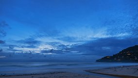 Time lapse beautiful blue sky above the ocean at Karon beach.
The setting sun creates a stunning contrast between the deep blue of 
the sky and the colorful hues of the clouds.