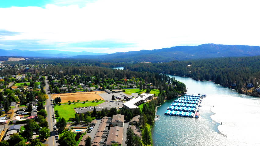 Aerial Panning Scenic View Of Boats At Harbor In River By Green Town On Sunny Day - Coeur d