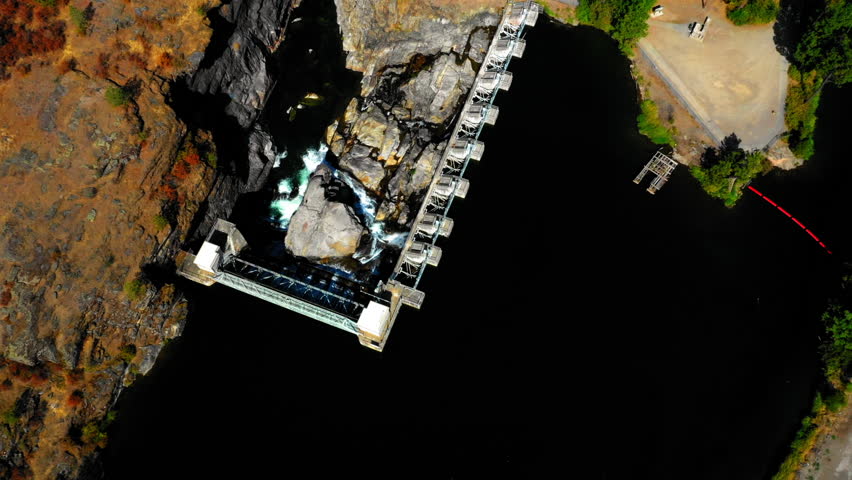 Aerial Tilt Up Shot Of Dam Bridge River By Residential Town Landscape On Sunny Day - Coeur d