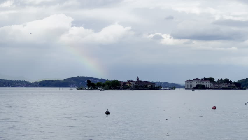 Rainbow Over Isola dei Pescatori and Isola Bella in Lake Maggiore, Italy, with Plane, Bird, and Dramatic Clouds