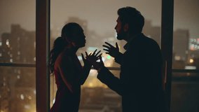 Married couple silhouettes quarrelling at luxury panoramic flat closeup. Wife husband having conflict making trouble. Angry man going away sad woman crying at big night window. Disagreement concept  - Powered by Shutterstock - Get 15% off with code: PIKWIZARD15