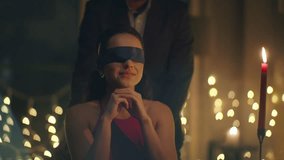 Gorgeous woman removing eyes bandage laughing happily about romantic surprise closeup. Cheerful husband embracing surprised happy wife at night candles atmosphere. Love couple celebrating anniversary - Powered by Shutterstock - Get 15% off with code: PIKWIZARD15