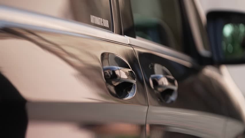 exclusive driver opens the electric door of the black van
