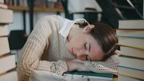 young woman student or businesswoman fell asleep on a stack of books in the library or classroom. Female was tired from reading books and fell asleep on books - Powered by Shutterstock - Get 15% off with code: PIKWIZARD15