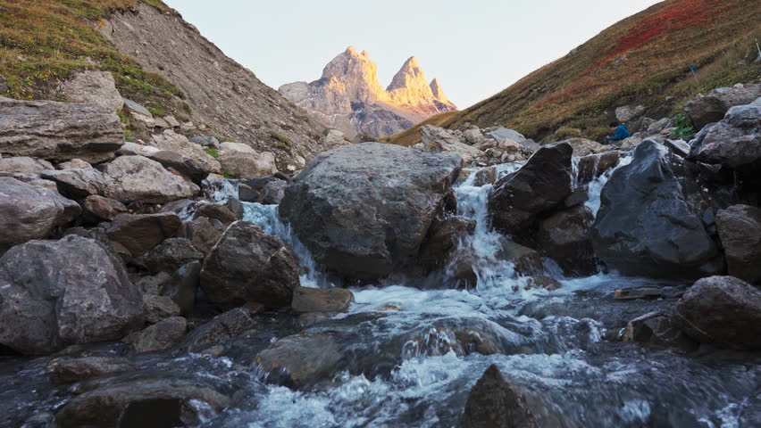 Landscape of Iconic seperate mountain peak of Aiguilles d Arves with waterfall flowing in French Alps valley on autumn at Savoie, France