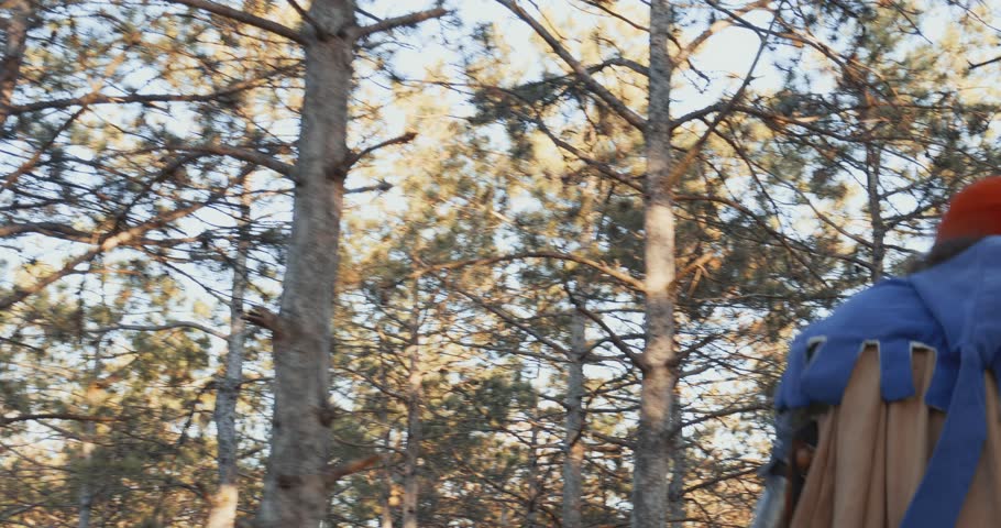 Walking in the forest A man with a beard in a medieval knight costume. Back view. Close-up. Reconstruction of historical events