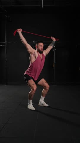 Video of handsome muscular man training with resistance band in gym. Routine workout for physical and mental health.