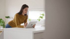 Woman managing features of smart home system, lowering temperature. Adjusting household functions, lighting, security cameras, door locks, thermostat or heating settings. Holding tablet, smart - Powered by Shutterstock - Get 15% off with code: PIKWIZARD15