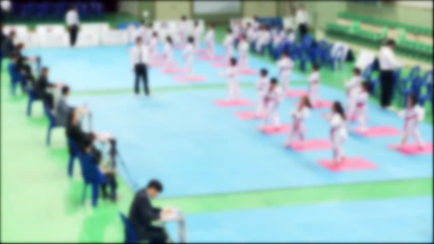 Blurred, children being screened for Taekwondo promotion and judges