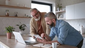Mature son helping father to manage his finance, teaching how to work with internet baking and shopping online. Handsome son supporting dad, technology and digital literacy. - Powered by Shutterstock - Get 15% off with code: PIKWIZARD15