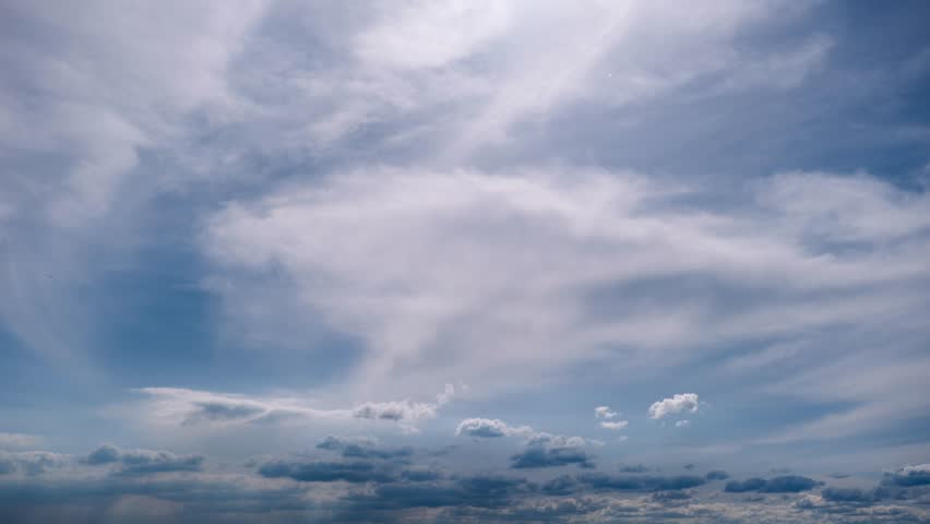 Timelapse clouds moves in the blue sky. The background of light and heavy calm cumulus clouds changes shape in cloudy space. Natural background, time-lapse, copy space. 4K.