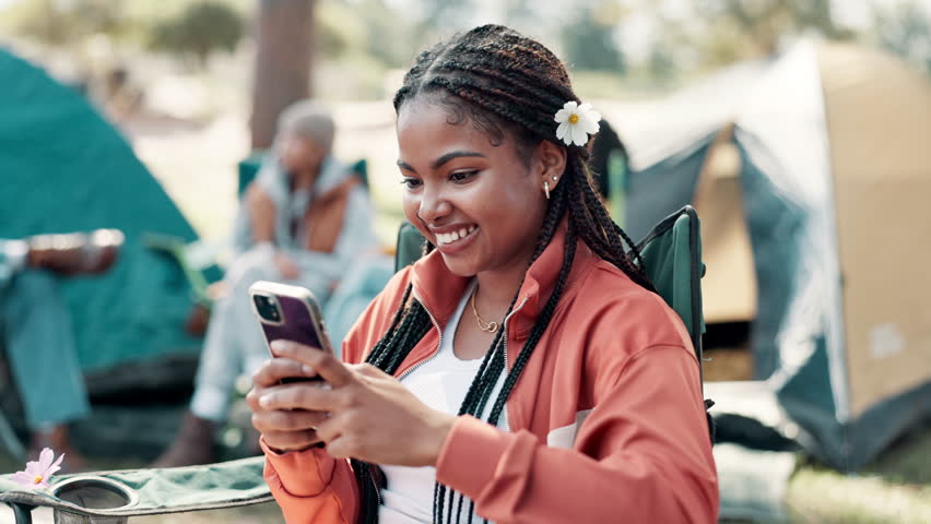 Camping, phone and black woman by tent with friends for holiday, vacation and adventure outdoors. Travel, campsite and person on smartphone for social media to relax in countryside, nature and forest