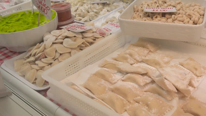 At the oriental market in Genoa, Italy, a stall selling local specialties of fresh stuffed pasta: the gaze passes over the trays with different formats with name and price tags.