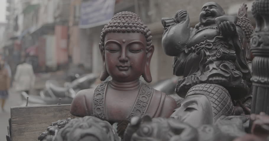 Souvenirs statues of Buddha head on flea market in Delhi, India. Buddha and other Indian gods statues. Close up. Ungraded C-LOG 2, ungraded.