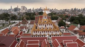 Aerial view of the Wat Ratchanatdaram Worawihan temple in Bangkok Thailand. Temple with stunning footage of its iconic Loha Prasat, intricate spires and rich architectural beauty hot in slow motion 4K