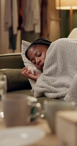 Sick, sneeze and woman on sofa with tissue for allergies, infection and flu virus in living room. Health, medical and person on couch with blanket for hayfever, influenza and sinus symptoms in home