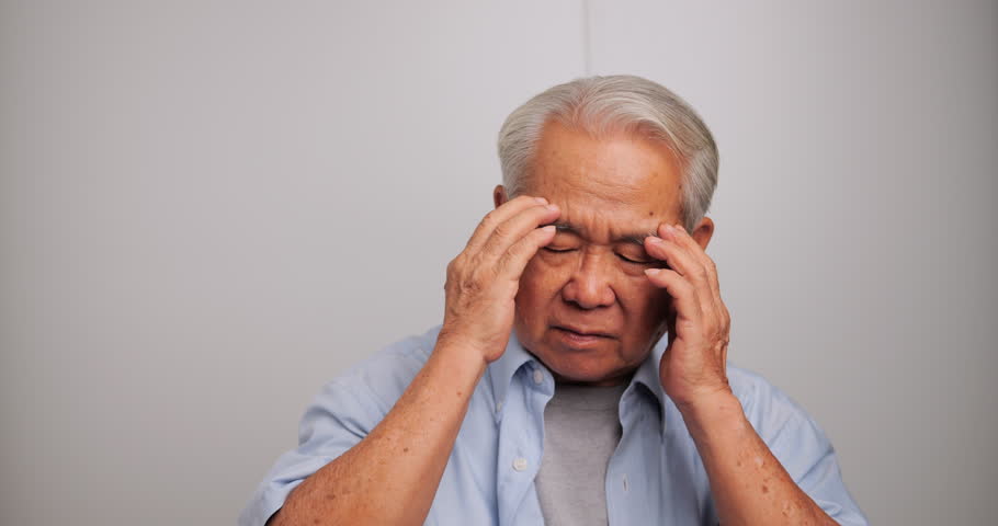 Asian old man with migraine headache. Elderly man suffering from a headache.
